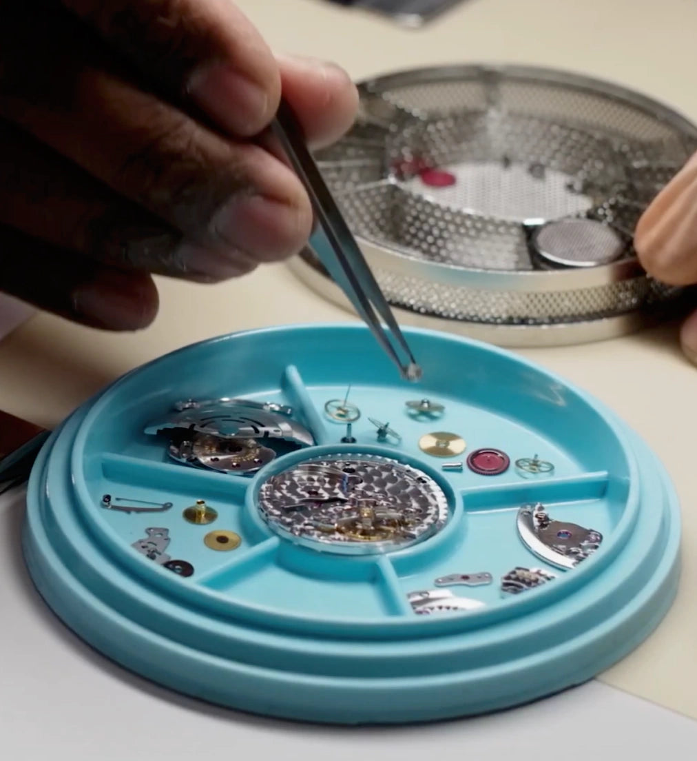 Watchmaker placing a component on a movement tray at the Edwards Lowell Aftersales & Repairs Centre